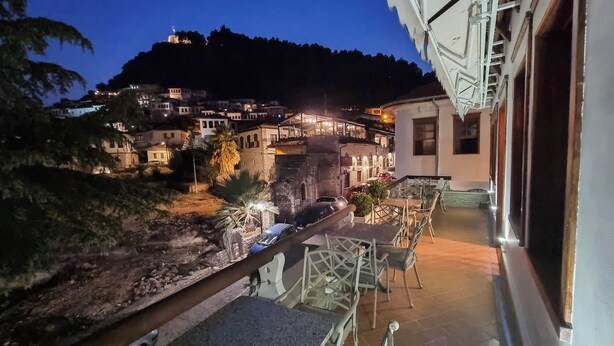 A view of a hillside village at night with buildings illuminated. - Master Hotel Berat (Berat)