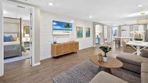 A spacious living area with a wooden floor, a sofa, a coffee table, and a dining area with a table and chairs. - Luxurious 2+ BR villa:highly sought after Naples Reserve for annual & seasonal (Naples)
