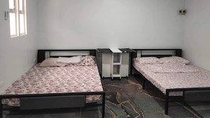 A room with two single beds, a small white table, and a window. - Affordable studio type guest house (Dagupan)