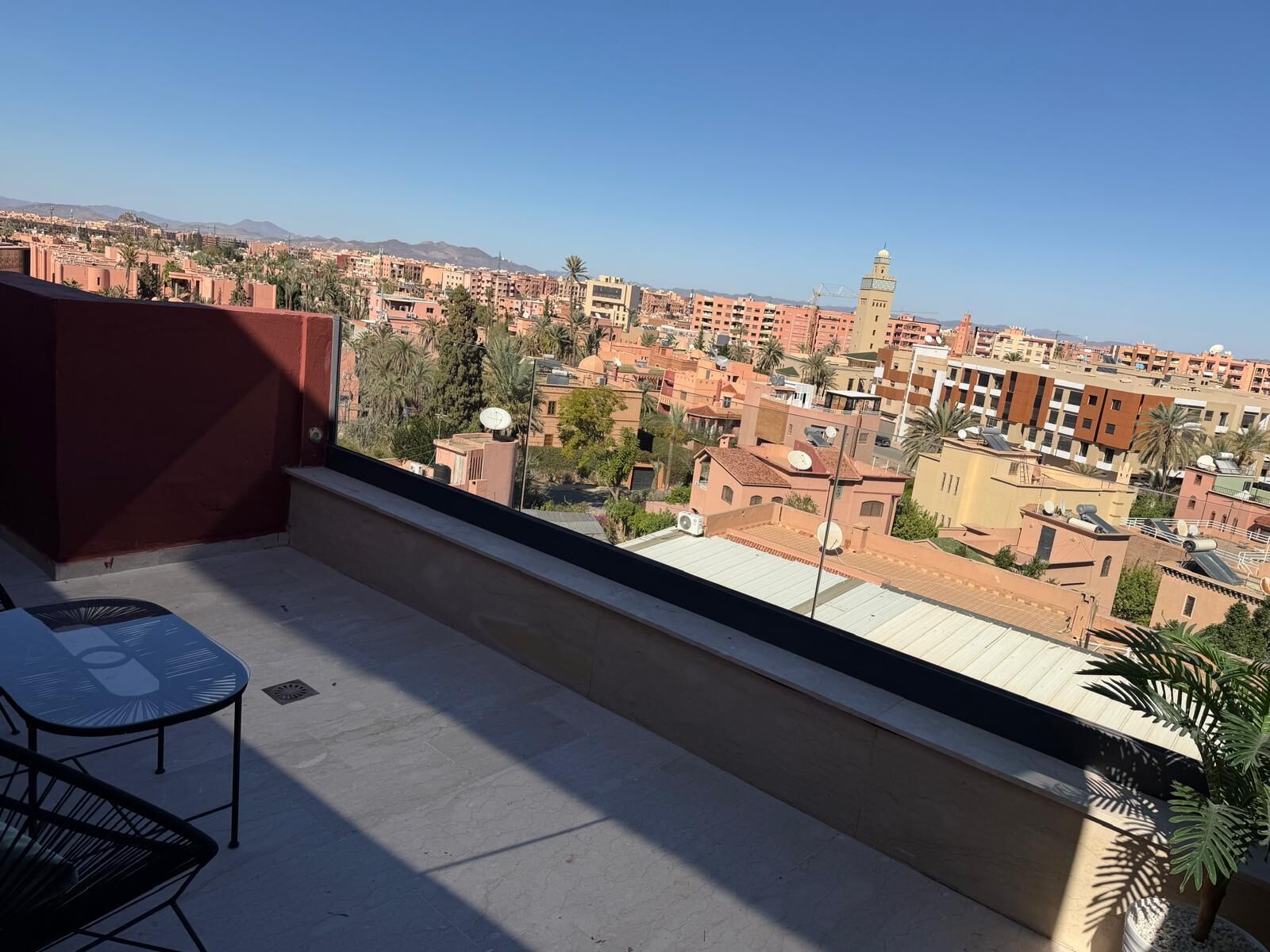 A balcony with a view of a cityscape, including a mosque with a minaret.
