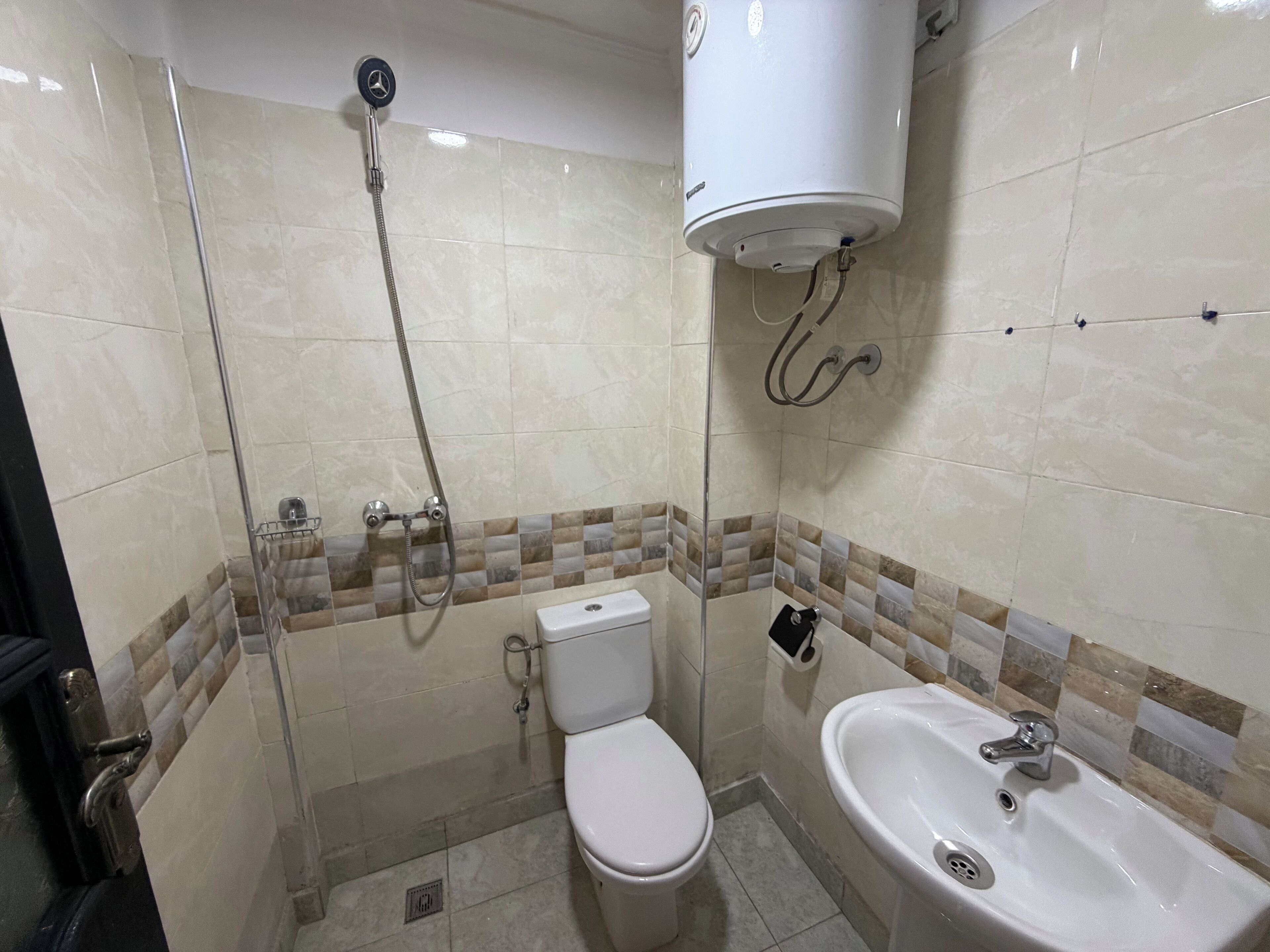 Un baño con inodoro, ducha y lavamanos.