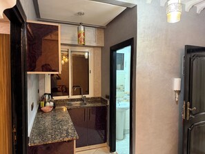 Una cocina moderna con encimeras de granito, pileta de acero inoxidable y horno empotrado.