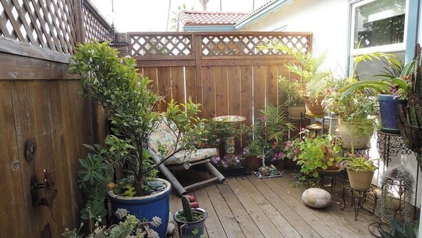 A wooden deck with potted plants and a patio table. - Cozy 1-bedroom sunset beach apartment in San Diego (San Diego)