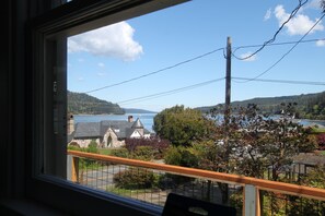 A view from a window overlooking a coastal town with a church, a body of water, and hills in the distance. - Scenic Hood Canal View Cottage with AC in charming Union (Union)