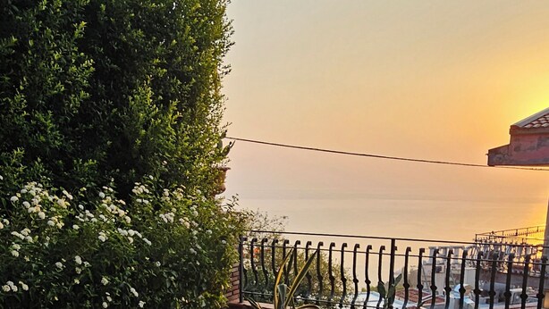 A terrace with wicker furniture and potted plants, overlooking a body of water. - Taormina Home La Terrazza di Fede. 5 minutes walk from downtown. Private car park (Taormina)