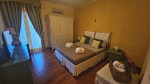 A bedroom with a bed, bedside tables, a wardrobe, a desk, and a window with curtains. - Taormina Home La Terrazza di Fede. 5 minutes walk from downtown. Private car park (Taormina)