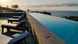 Ein Infinity-Pool mit Liegestühlen mit Blick auf den Ozean.