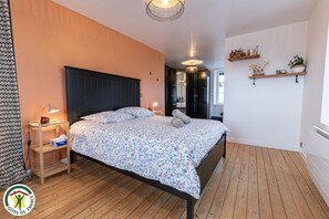 Une chambre à coucher comprenant un lit, des tables de chevet, une commode, un miroir et une étagère avec des objets décoratifs.