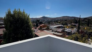 Eine Dachterrasse mit freiem Blick auf eine Stadt und die entfernten Hügel.