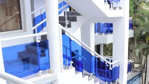 Ein mehrgeschossiges Gebäude mit Glasgeländern und weißen Bauelementen.