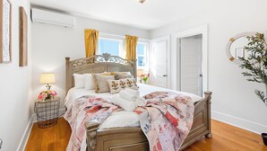 A bedroom with a wooden bed, a bedside table with a lamp, and a window with curtains. - King Bed Comfort Ultra Spacious Gem Prime Location south pasadena! (South Pasadena)