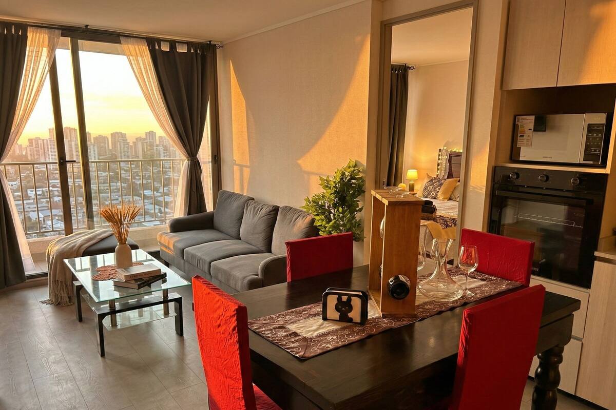 Ein modernes Wohnzimmer mit Sofa, Glastisch und Essbereich für zwei Personen.