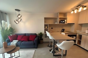 Un salon moderne comprenant un canapé, une table basse et un coin repas avec une table et des chaises.