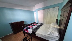 Une chambre à coucher avec un lit, une commode et une chaise.