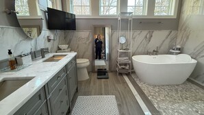A modern bathroom with a large bathtub, a double sink vanity, a toilet, and a mirror. - Perfect location - renovated home w/2 master suites & exceptional outdoor space. (Washington)