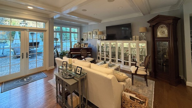 A spacious living room with a large window, a piano, a television, and a clock. - Perfect location - renovated home w/2 master suites & exceptional outdoor space. (Washington)
