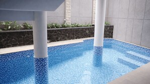 A swimming pool with a mosaic tile design, surrounded by stone walls and a tiled deck. - Miracle Hotel Cianjur (Cianjur)
