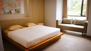 A modern bedroom with a large bed, a sofa, and a window with curtains. - Miracle Hotel Cianjur (Cianjur)