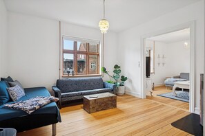 A modern living room with a sofa, a coffee table, and a large window.