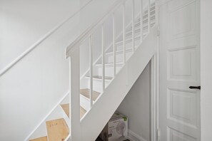 A white staircase with a box labeled 'Nordic Home Desk Fan' on the landing.