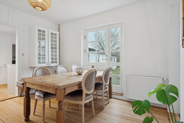 A dining area with a wooden table, chairs, and a window with a view.