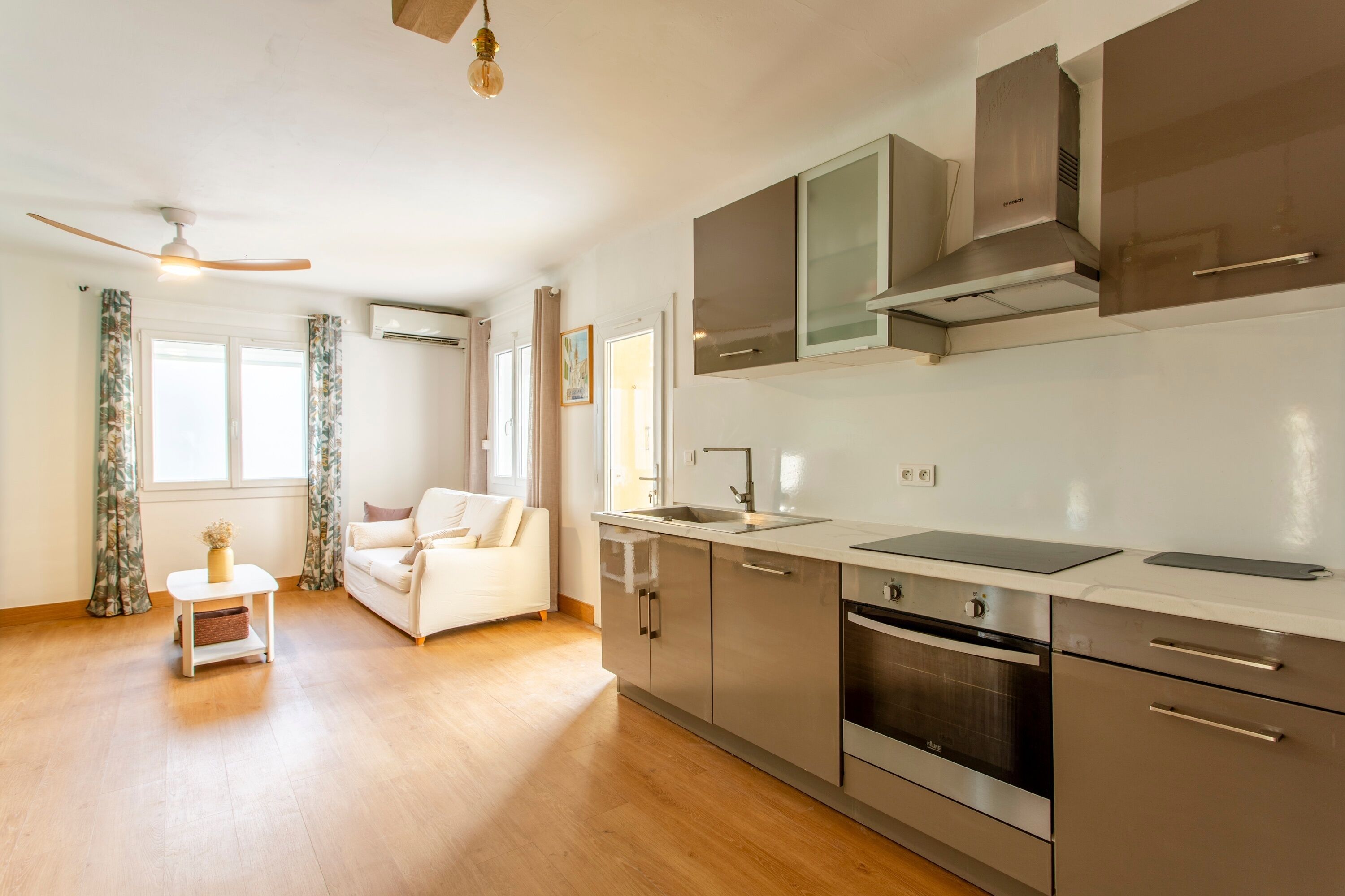 A modern kitchen with stainless steel appliances, a white countertop, and a built-in oven.