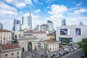 Paesaggio urbano con architettura storica, grattacieli moderni e un arco imponente.
