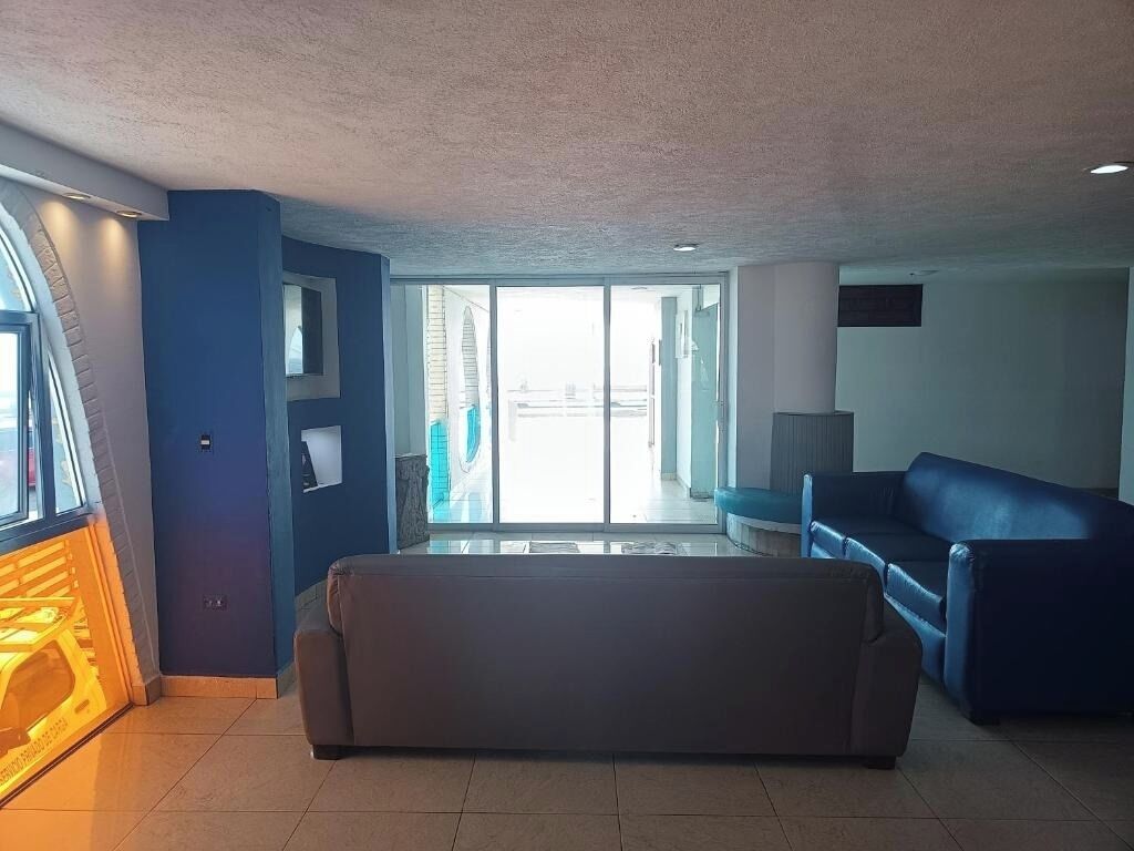 Een moderne woonkamer met een bank, een televisie en een groot raam.