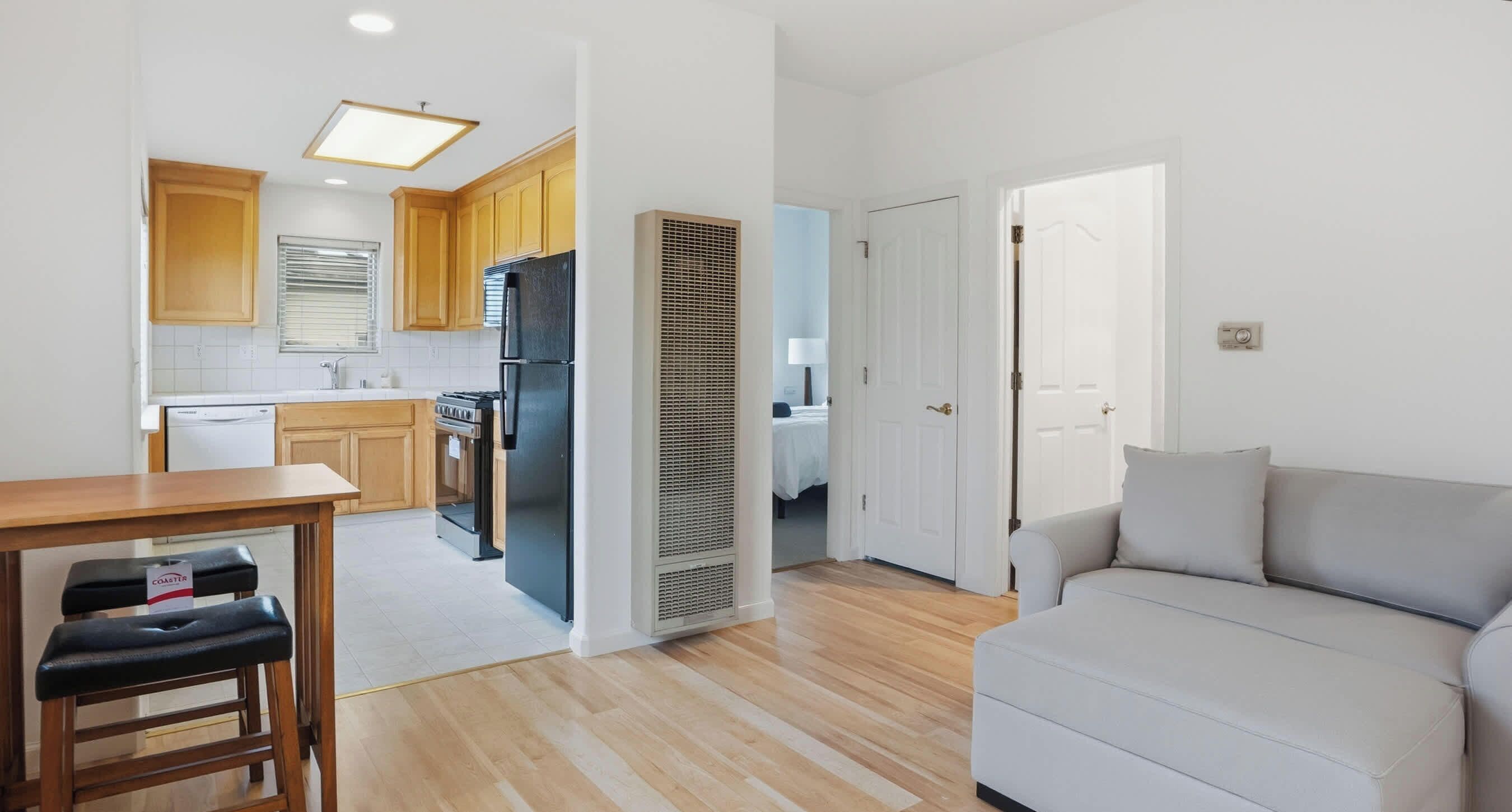 A compact living space with a kitchenette, a dining area, and a seating area.