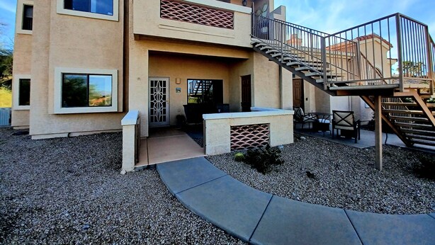 A two-story building with a balcony, a staircase, and a patio area with outdoor furniture. - Sparkling Clean 'Javelina Hideaway' in Beautiful Fountain Hills (Fountain Hills)