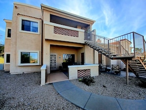 A two-story building with a balcony, a staircase, and a patio area with outdoor furniture. - Sparkling Clean 'Javelina Hideaway' in Beautiful Fountain Hills (Fountain Hills)