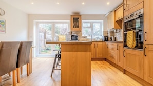 Una cocina moderna con armarios de madera, una isla central y un amplio ventanal.