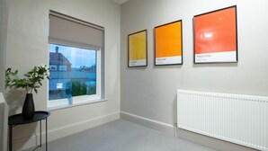 A room with a large window, a radiator, and three framed Pantone color samples on the wall. - Brattan Road -  a house that sleeps 5 guests  in 5 bedrooms (Oxton)
