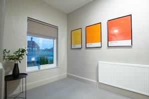 A room with a large window, a radiator, and three framed Pantone color samples on the wall. - Brattan Road -  a house that sleeps 5 guests  in 5 bedrooms (Oxton)