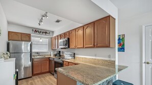 A modern kitchen with wooden cabinets, stainless steel appliances, and a granite countertop. - Prime Location/2 Bdr/Sleeps 7/Pet friendly (Santa Rosa Beach)