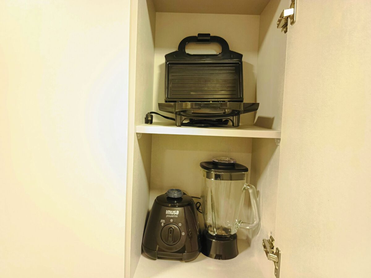 Una cucina con un piano di lavoro, un frullatore e una macchina per il caffè.