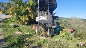 Un edificio con un letrero que dice 'TERRAZAS DEL ARENAL' y un cartel de estacionamiento.