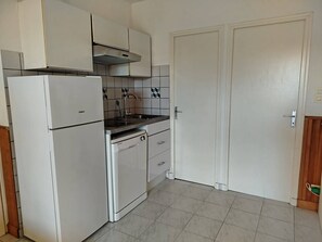 A compact kitchen with white cabinetry, a built-in dishwasher, and a stove. - One-bedroom flat on the ground floor with terrace - sleeps 5 - 5RICHE23 (SAINT CYPRIEN PLAGE)