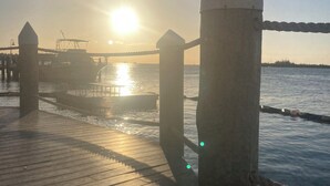 Un muelle de madera con barandilla que se extiende hacia el agua.