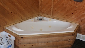 Una baita di legno con una vasca da bagno in legno di grandi dimensioni.