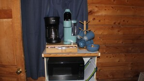 Un piano di lavoro in cucina con una macchina da caffè, un frullatore, un forno a microonde e un tostapane.