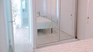A bedroom with a bed, a bedside table, and a wardrobe. - 2-bedroom, walk to the beach, reserved parking, AC in each bedroom (San Juan)