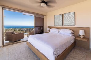 A bedroom with a large bed, a ceiling fan, and a view of the ocean through a sliding door. - Private Rooftop Pool - Ocean View Romantic Getaway (Cabo San Lucas)