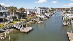 A marina with boats docked, wooden walkways, and residential buildings. - Sunsets, Sand & Boat-Ready Getaway (Holden Beach)