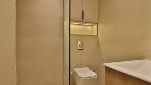 Une salle de bain moderne avec une douche à parois de verre, des toilettes blanches et une baignoire sur pieds.