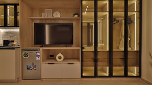 Une cuisine moderne équipée d’un téléviseur encastré, d’un réfrigérateur et d’un meuble en bois.