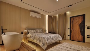 Une chambre à coucher moderne avec un grand lit, une baignoire et un plancher en bois.