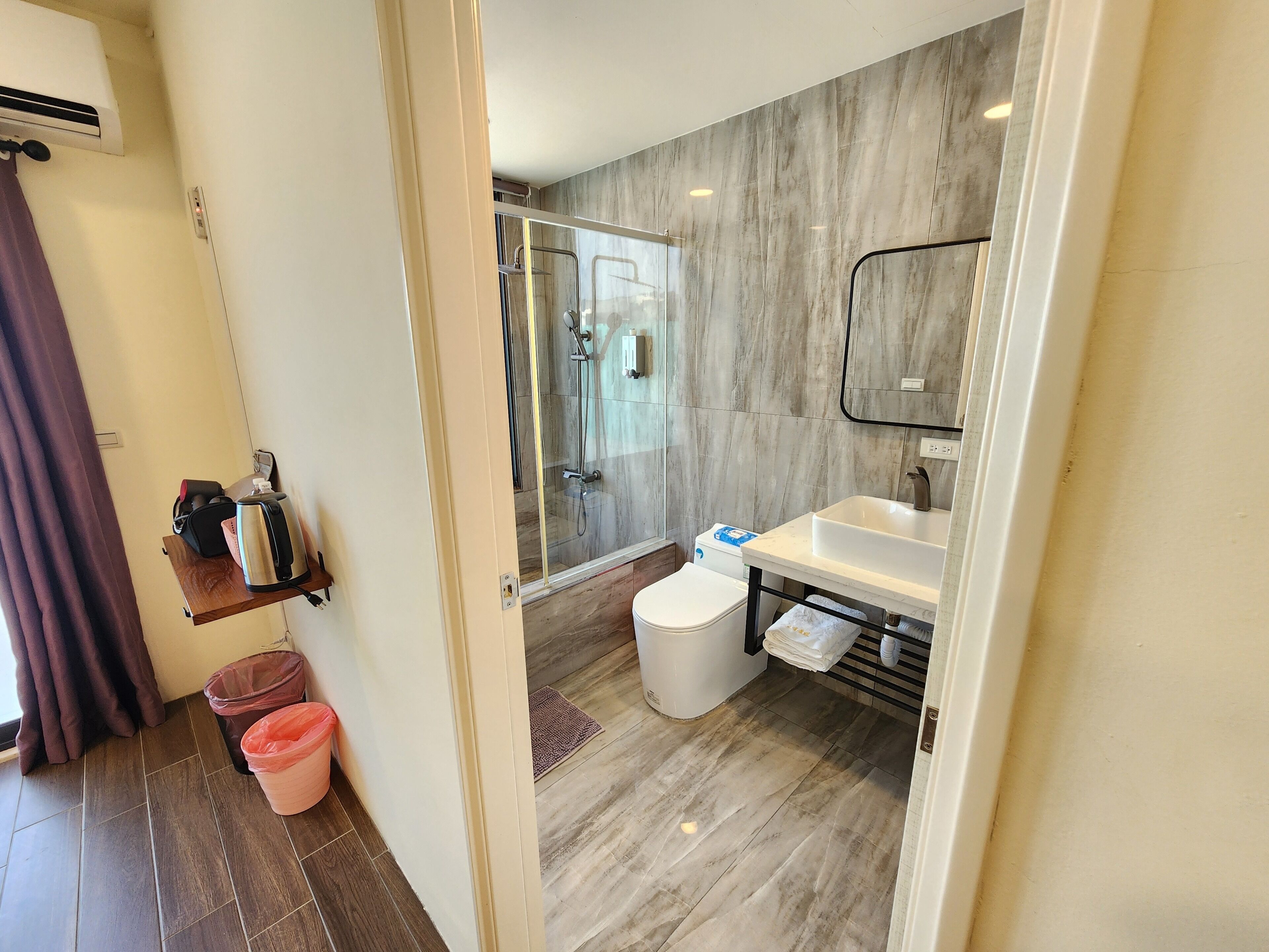 Un baño moderno con cabina de ducha de vidrio, lavabo blanco y un inodoro.