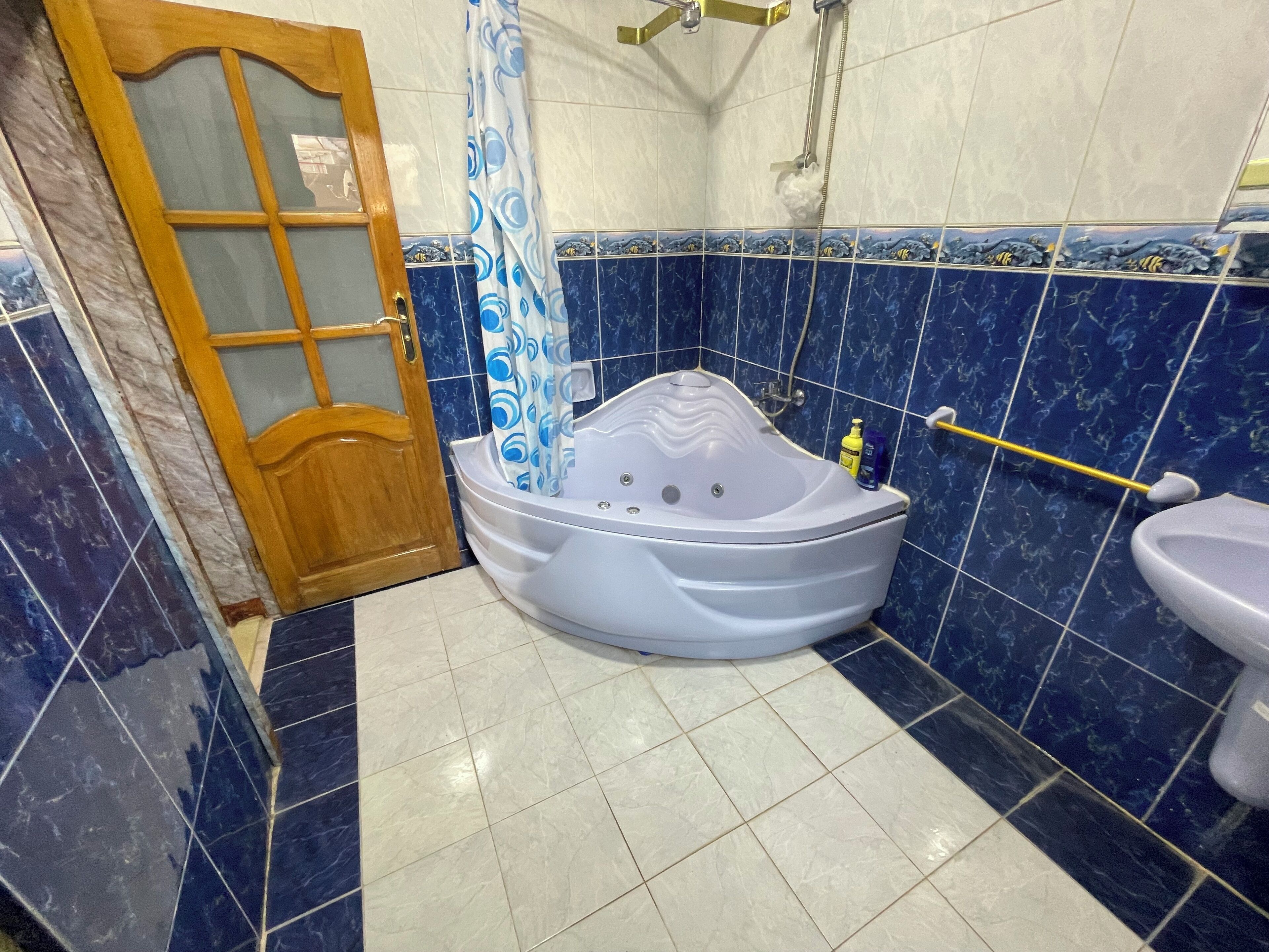 A bathroom with a jacuzzi, a toilet, and a shower.