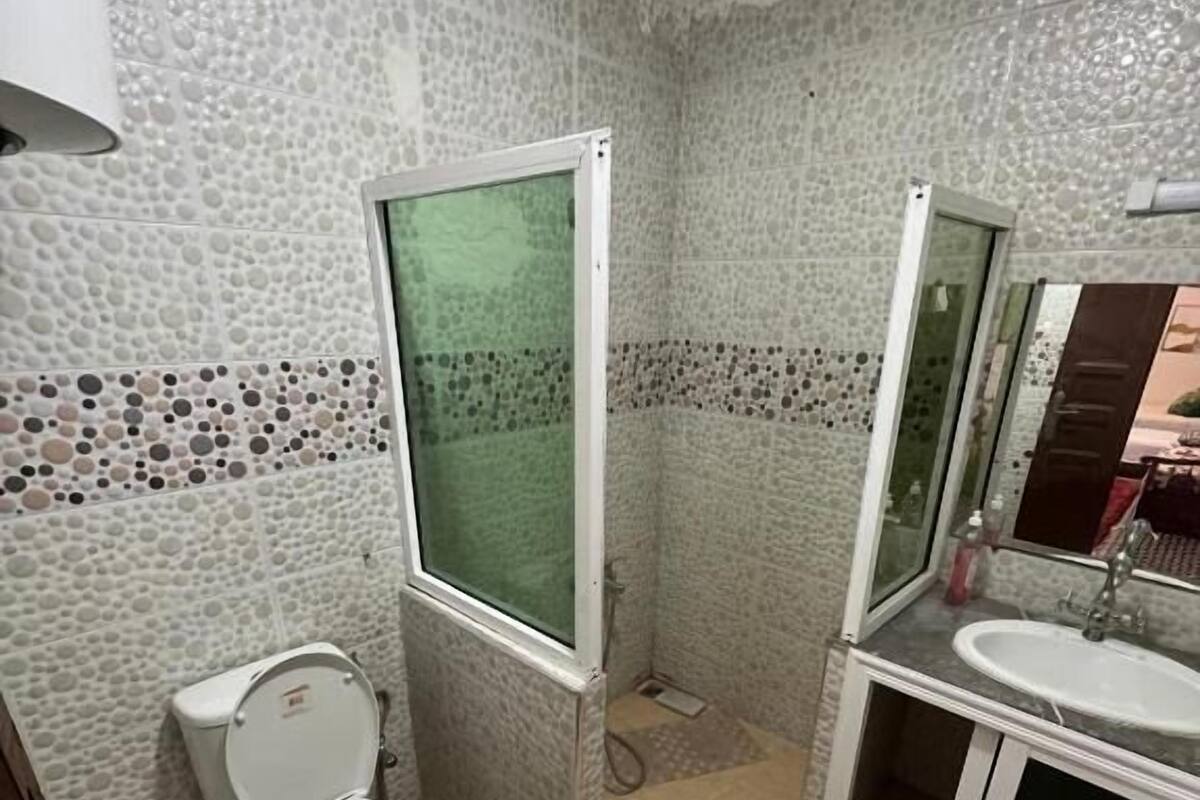 A bathroom with a toilet, a shower, and a sink.